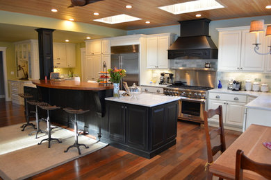 Eat-in kitchen - mid-sized traditional medium tone wood floor eat-in kitchen idea in Chicago with raised-panel cabinets, white cabinets, marble countertops, gray backsplash, stainless steel appliances and an island