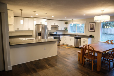 Example of a mid-sized minimalist u-shaped porcelain tile and brown floor eat-in kitchen design in Portland with an undermount sink, shaker cabinets, white cabinets, quartzite countertops, gray backsplash, stainless steel appliances, a peninsula and gray countertops