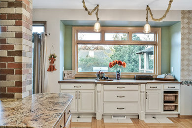 Inspiration for a mid-sized timeless galley light wood floor and brown floor enclosed kitchen remodel in Milwaukee with raised-panel cabinets, white cabinets, wood countertops and an island