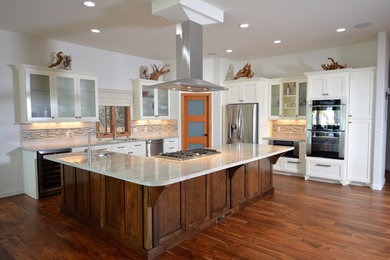 Large transitional l-shaped dark wood floor and brown floor kitchen photo in San Diego with stainless steel appliances, an undermount sink, shaker cabinets, white cabinets, granite countertops, beige backsplash, stone tile backsplash and an island