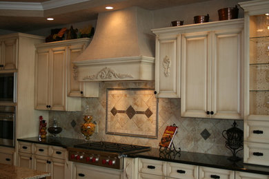 Example of a large classic ceramic tile eat-in kitchen design in Milwaukee with a double-bowl sink, raised-panel cabinets, granite countertops, beige backsplash, porcelain backsplash, stainless steel appliances and an island