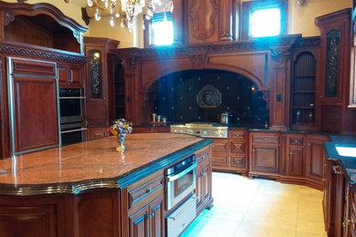 Example of a large transitional ceramic tile kitchen design in Other with raised-panel cabinets, dark wood cabinets, granite countertops, stainless steel appliances and an island