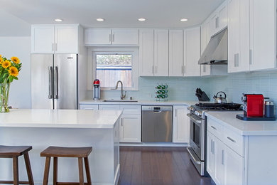 Inspiration for a large timeless l-shaped dark wood floor eat-in kitchen remodel in San Francisco with a drop-in sink, white cabinets, blue backsplash, ceramic backsplash, stainless steel appliances and an island