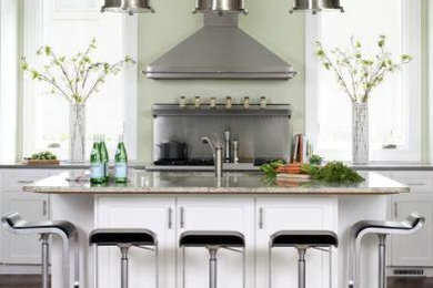 На фото: угловая кухня-гостиная в стиле неоклассика (современная классика) с фасадами в стиле шейкер, белыми фасадами, гранитной столешницей и техникой из нержавеющей стали