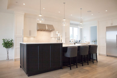 Example of a large transitional single-wall light wood floor and beige floor eat-in kitchen design in Vancouver with an undermount sink, recessed-panel cabinets, white cabinets, solid surface countertops, white backsplash, mosaic tile backsplash, stainless steel appliances, an island and white countertops