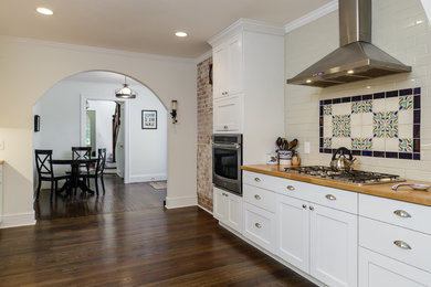 Inspiration for a large transitional l-shaped dark wood floor eat-in kitchen remodel in Raleigh with shaker cabinets, white cabinets, stainless steel appliances, a farmhouse sink, beige backsplash, subway tile backsplash and no island