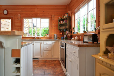 Inredning av ett klassiskt mellanstort kök, med en dubbel diskho, skåp i shakerstil, vita skåp, rostfria vitvaror, klinkergolv i keramik och en köksö