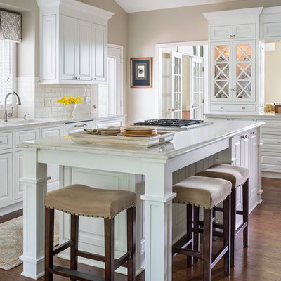 Inspiration for a large timeless u-shaped dark wood floor eat-in kitchen remodel in Minneapolis with an undermount sink, white cabinets, white backsplash, subway tile backsplash, an island, raised-panel cabinets and granite countertops