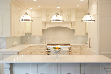 Large transitional u-shaped medium tone wood floor and brown floor open concept kitchen photo in Chicago with a farmhouse sink, raised-panel cabinets, white cabinets, quartzite countertops, blue backsplash, glass tile backsplash, stainless steel appliances and two islands