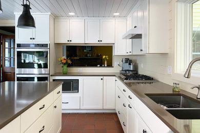 This is an example of a medium sized traditional l-shaped open plan kitchen in Boston with a submerged sink, recessed-panel cabinets, white cabinets, composite countertops, beige splashback, wood splashback, stainless steel appliances, terracotta flooring, an island, red floors and brown worktops.