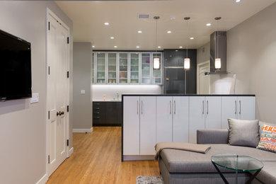 サンフランシスコにあるコンテンポラリースタイルのおしゃれなキッチン (ガラス扉のキャビネット、黒いキャビネット、白いキッチンパネル、パネルと同色の調理設備) の写真