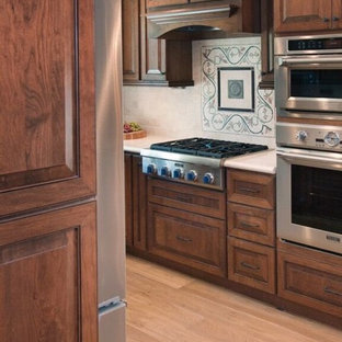 Photo of a mid-sized modern galley eat-in kitchen in San Francisco with louvered cabinets, red cabinets, quartz benchtops, beige splashback, subway tile splashback, stainless steel appliances, laminate floors, a drop-in sink and no island.