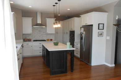 Mid-sized trendy u-shaped bamboo floor and brown floor eat-in kitchen photo in Columbus with a double-bowl sink, shaker cabinets, white cabinets, quartzite countertops, gray backsplash, glass tile backsplash, stainless steel appliances and an island
