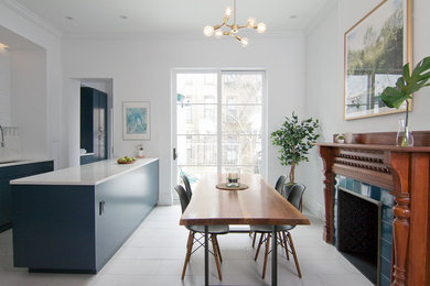 Example of a mid-sized danish l-shaped porcelain tile and gray floor eat-in kitchen design in New York with a single-bowl sink, shaker cabinets, blue cabinets, quartz countertops, white backsplash, brick backsplash, stainless steel appliances and an island