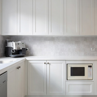 Example of a large classic l-shaped porcelain tile and brown floor open concept kitchen design in Sydney with an undermount sink, shaker cabinets, beige cabinets, quartz countertops, gray backsplash, stainless steel appliances, an island, white countertops and porcelain backsplash