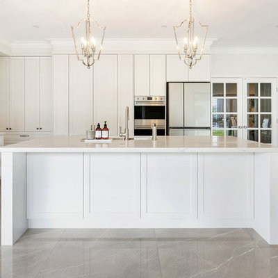 Example of a large classic l-shaped porcelain tile and brown floor open concept kitchen design in Sydney with an undermount sink, shaker cabinets, beige cabinets, quartz countertops, gray backsplash, stone slab backsplash, stainless steel appliances, an island and white countertops