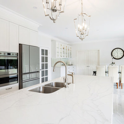 Example of a large classic l-shaped porcelain tile and brown floor open concept kitchen design in Sydney with an undermount sink, shaker cabinets, beige cabinets, quartz countertops, gray backsplash, stone slab backsplash, stainless steel appliances, an island and white countertops
