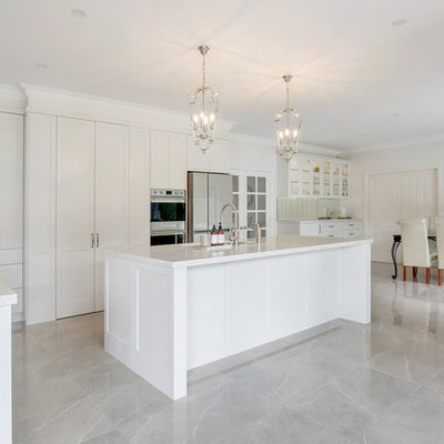 Example of a large classic l-shaped porcelain tile and brown floor open concept kitchen design in Sydney with an undermount sink, shaker cabinets, beige cabinets, quartz countertops, gray backsplash, stone slab backsplash, stainless steel appliances, an island and white countertops