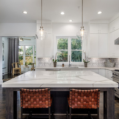 Transitional u-shaped dark wood floor and brown floor kitchen photo in Atlanta with an undermount sink, flat-panel cabinets, white cabinets, gray backsplash, stainless steel appliances, an island and white countertops