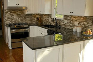 Mid-sized transitional u-shaped eat-in kitchen photo in Cincinnati with an undermount sink, shaker cabinets, white cabinets, granite countertops, multicolored backsplash, stainless steel appliances and a peninsula