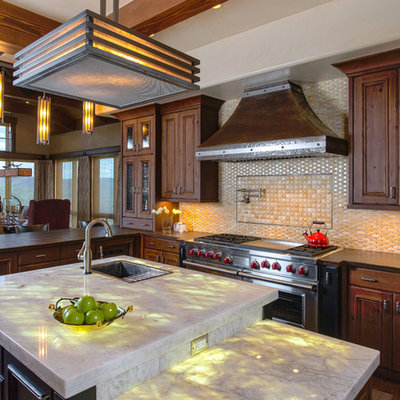 Large mountain style medium tone wood floor and brown floor eat-in kitchen photo in Other with a drop-in sink, medium tone wood cabinets, onyx countertops, beige backsplash, recessed-panel cabinets and an island