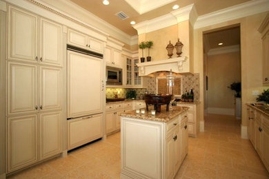 Mid-sized elegant galley ceramic tile kitchen pantry photo in Miami with beaded inset cabinets, white cabinets, granite countertops, beige backsplash, mosaic tile backsplash, white appliances and an island