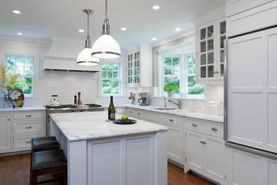 Elegant l-shaped kitchen photo in New York with an undermount sink, shaker cabinets, white cabinets, white backsplash, subway tile backsplash and paneled appliances