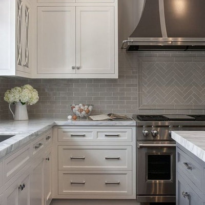 Inspiration for a contemporary dark wood floor and brown floor kitchen remodel in Raleigh with an undermount sink, recessed-panel cabinets, white cabinets, marble countertops, gray backsplash, subway tile backsplash, stainless steel appliances, an island and multicolored countertops