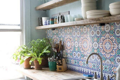 Inspiration for a mid-sized timeless single-wall cement tile floor enclosed kitchen remodel in Miami with a drop-in sink, louvered cabinets, gray cabinets, wood countertops, multicolored backsplash, cement tile backsplash, stainless steel appliances and an island