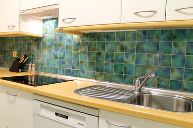 他の地域にあるラスティックスタイルのおしゃれなキッチン (緑のキッチンパネル、セラミックタイルのキッチンパネル) の写真