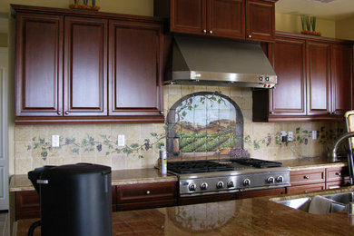 Example of a tuscan kitchen design in Orange County with stone tile backsplash
