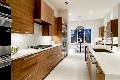 Eat-in kitchen - large contemporary single-wall porcelain tile and beige floor eat-in kitchen idea in Los Angeles with a double-bowl sink, flat-panel cabinets, medium tone wood cabinets, quartz countertops, white backsplash, stone tile backsplash, stainless steel appliances and an island
