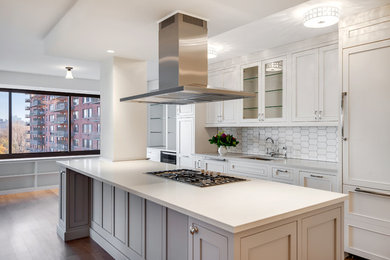 Example of a mid-sized trendy single-wall dark wood floor and brown floor enclosed kitchen design in New York with an undermount sink, beaded inset cabinets, white cabinets, quartz countertops, white backsplash, porcelain backsplash, paneled appliances, an island and white countertops