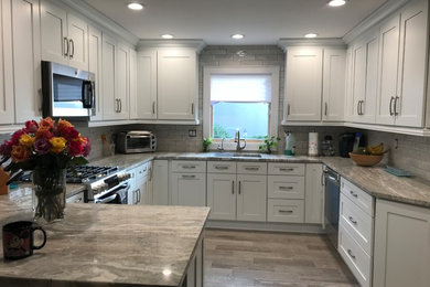 Kitchen - small transitional u-shaped porcelain tile and gray floor kitchen idea in New York with an undermount sink, shaker cabinets, white cabinets, granite countertops, gray backsplash, subway tile backsplash, stainless steel appliances, a peninsula and multicolored countertops