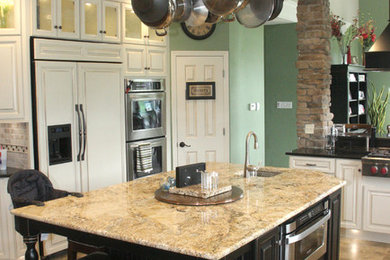 Exempel på ett stort kök med öppen planlösning, med en undermonterad diskho, luckor med upphöjd panel, vita skåp, granitbänkskiva, beige stänkskydd, stänkskydd i stenkakel, rostfria vitvaror och en köksö