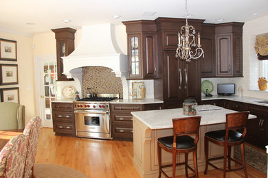 Large elegant galley light wood floor and brown floor eat-in kitchen photo in Philadelphia with an undermount sink, recessed-panel cabinets, dark wood cabinets, granite countertops, multicolored backsplash, stainless steel appliances and an island