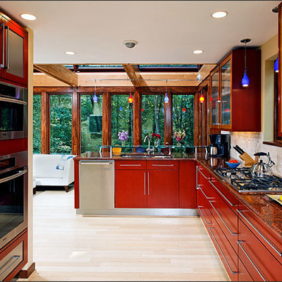 Open concept kitchen - large eclectic galley light wood floor open concept kitchen idea in DC Metro with a drop-in sink, glass-front cabinets, medium tone wood cabinets, granite countertops, beige backsplash, ceramic backsplash, stainless steel appliances and no island