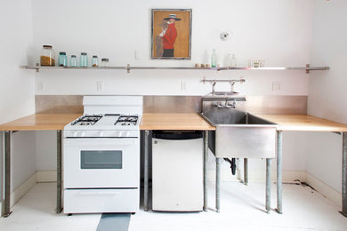 ニューヨークにあるインダストリアルスタイルのおしゃれなI型キッチン (エプロンフロントシンク、白い調理設備) の写真