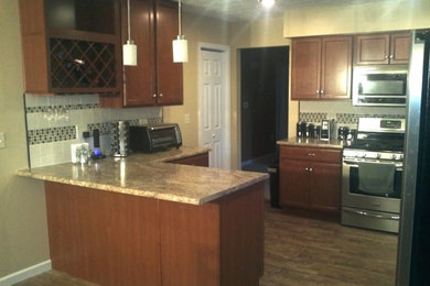 Photo of a medium sized l-shaped open plan kitchen in Louisville with recessed-panel cabinets, medium wood cabinets, granite worktops, white splashback, ceramic splashback, stainless steel appliances, medium hardwood flooring and a breakfast bar.