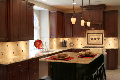 Mid-sized elegant l-shaped porcelain tile and beige floor eat-in kitchen photo in St Louis with an undermount sink, raised-panel cabinets, brown cabinets, granite countertops, beige backsplash, travertine backsplash, stainless steel appliances and an island