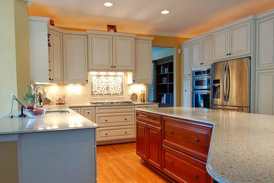 Large elegant l-shaped open concept kitchen photo in DC Metro with raised-panel cabinets and an island