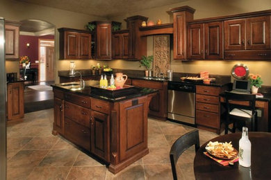 Large tuscan u-shaped travertine floor and multicolored floor eat-in kitchen photo in Orange County with an undermount sink, raised-panel cabinets, dark wood cabinets, stainless steel appliances and an island