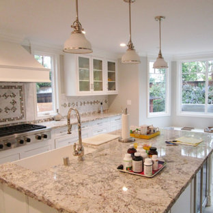 Mid-sized transitional eat-in kitchen inspiration - Eat-in kitchen - mid-sized transitional single-wall eat-in kitchen idea with a farmhouse sink, recessed-panel cabinets, white cabinets, granite countertops, multicolored backsplash, porcelain backsplash, paneled appliances, an island and multicolored countertops