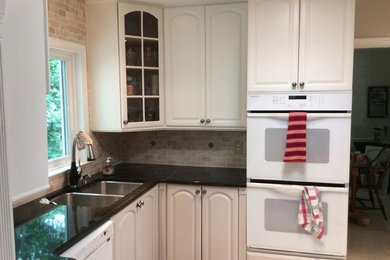 Foto de cocina contemporánea pequeña con fregadero de doble seno, electrodomésticos blancos, suelo de pizarra y encimeras negras