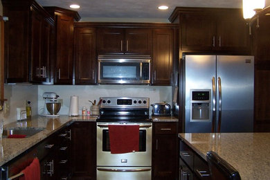 Mid-sized l-shaped eat-in kitchen photo in Other with a double-bowl sink, dark wood cabinets, granite countertops, stainless steel appliances and an island