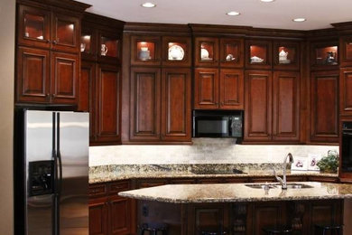 Kitchen pantry - large u-shaped kitchen pantry idea in Phoenix with an integrated sink, raised-panel cabinets, medium tone wood cabinets, granite countertops, white backsplash, ceramic backsplash, stainless steel appliances and an island