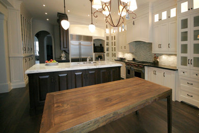 Eat-in kitchen - large traditional l-shaped dark wood floor eat-in kitchen idea in Toronto with a double-bowl sink, shaker cabinets, white cabinets, quartz countertops, blue backsplash, matchstick tile backsplash, stainless steel appliances and an island