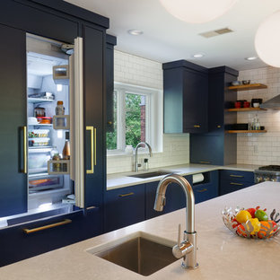 This is an example of a midcentury kitchen in Cincinnati with an undermount sink, flat-panel cabinets, blue cabinets, white splashback, cork floors and with island.