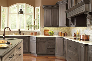 Klassische Küche mit Schrankfronten mit vertiefter Füllung, grauen Schränken, bunter Rückwand und weißer Arbeitsplatte in Sonstige