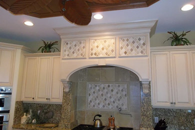 Example of a mid-sized transitional l-shaped kitchen design in Tampa with raised-panel cabinets, beige cabinets, granite countertops, multicolored backsplash, stainless steel appliances and stone slab backsplash